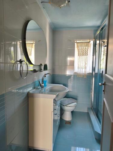 a bathroom with a sink and a toilet and a mirror at Parga Heritage in Parga