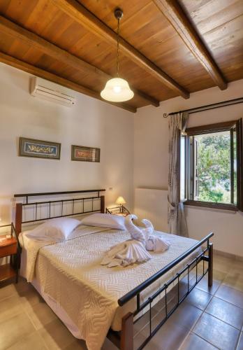 a bedroom with a large bed with a wooden ceiling at Rodoula apts By Comfortbnb in Roússa Ekklisía