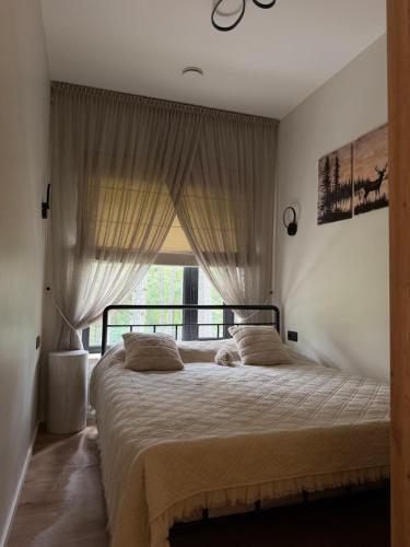 a bedroom with a large bed with a window at Beiri in Dravnieki