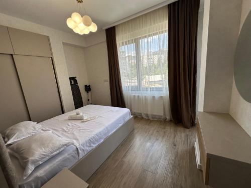 a bedroom with a bed and a large window at GM Apartment in Tbilisi City
