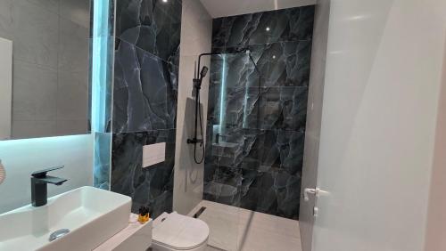 ein Badezimmer mit Dusche, Toilette und Waschbecken in der Unterkunft Hotel Velaris in Struga