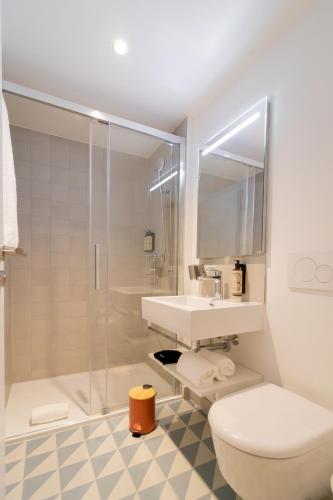 ein Badezimmer mit Toilette, Waschbecken und Dusche in der Unterkunft HOOD Hotel in Genf