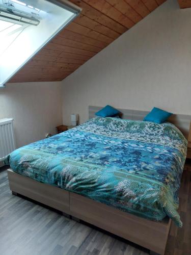 ein Schlafzimmer mit einem Bett mit blauer Bettdecke in der Unterkunft Baloe in Manderfeld