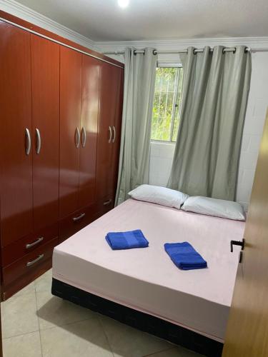 a bedroom with a bed with blue towels on it at Apartamento térreo bem equipado, fácil acesso in Canoas