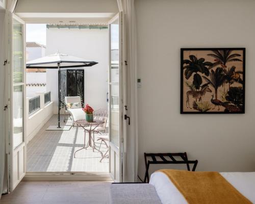 a bedroom with a balcony with a table and an umbrella at La Fonda Heritage Hotel Luxury, Relais & Châteaux in Marbella