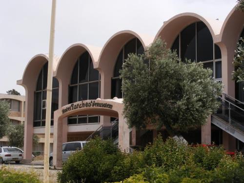 a building with a tree in front of it at Seven Arches Hotel in Jerusalem