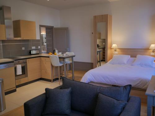 a bedroom with a large bed and a kitchen with a table at Résidence de Tourisme Central Parc Tours in Tours