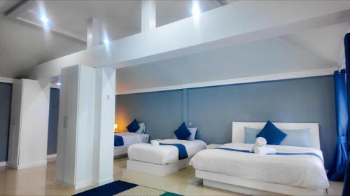 a bedroom with two beds with blue walls at Bann Sunset Cove Krabi I A Hidden Luxury Escape on Had Yao Beach in Krabi