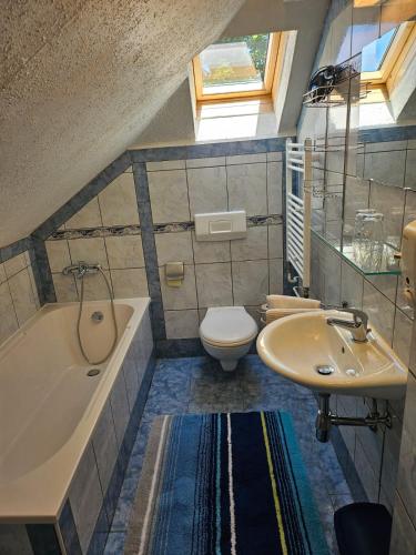 a bathroom with a tub and a toilet and a sink at Haus am Schönberg in Sooss