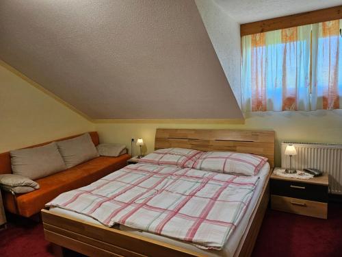 a bedroom with a bed and a couch at Haus am Schönberg in Sooss