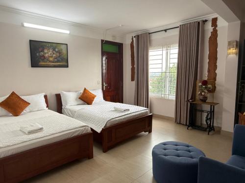 a hotel room with two beds and a chair at Khách sạn Hùng Thắng in Vĩnh Lộc