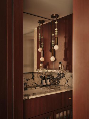 a bathroom with a sink and a large mirror at The Shepherd Mayfair in London
