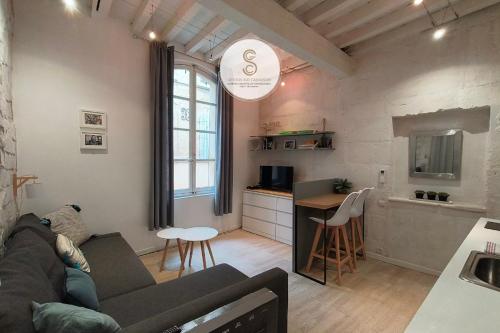 a living room with a couch and a kitchen at Côté Calade Arles Centre in Arles