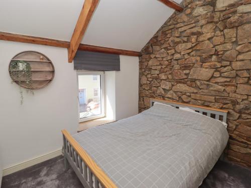 a bedroom with a stone wall and a bed at 41 St James Street in Narberth