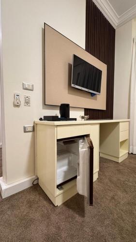 a room with a desk with a television on a wall at Rosaio in El Alamein