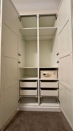 an empty closet with white cabinets and a stove at Rosaio in El Alamein