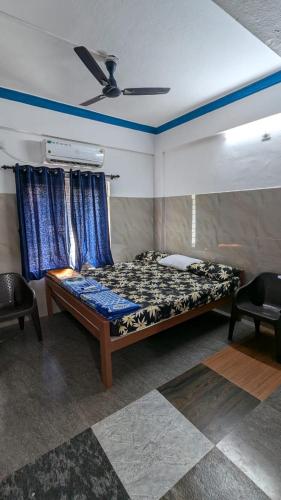 a bedroom with a bed and a ceiling fan at HOLIDAY HOMEs MALPE in Udupi