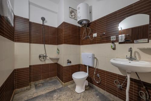 a bathroom with a toilet and a sink at The Prakriti Retreat l Pure Veg l Lift l Indoor Multi Cuisine Restaurant l Power Backup Available l Managed By ExoticStays Group in Kūfrī