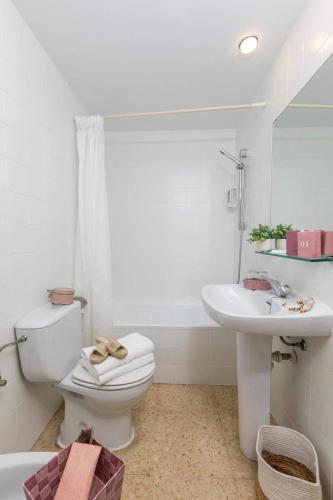 a white bathroom with a toilet and a sink at Hotel Bulevard in Platja d'Aro