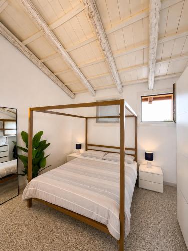 a bedroom with a canopy bed in a white room at Baco Da Seta Residence con Piscina - Venezia Mestre in Mestre