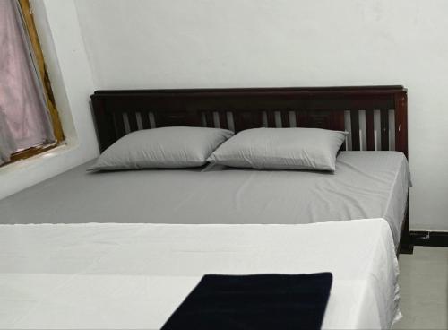 a bed with two pillows in a room at Queens luma villa in Arugam Bay