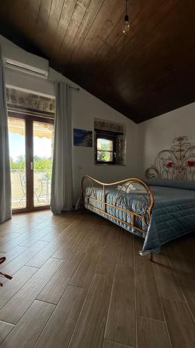 a bedroom with a bed and a wooden floor at Masseria Marotta in Santa Paolina