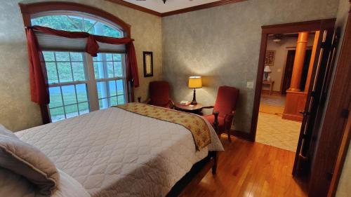 a bedroom with a bed and a large window at North River Inn in Bridgewater