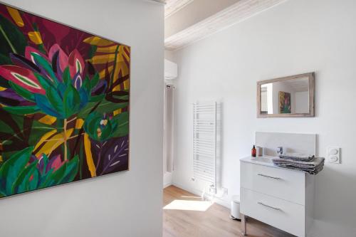 a painting on a wall in a room with a dresser at Chambre d'hôtes Château Austerlitz in Libourne
