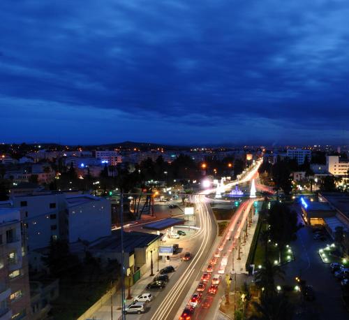 a city skyline at night with traffic on a highway at Hôtel l'escale in Fès
