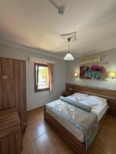 a bedroom with a large bed and a window at Ozukara Apart 1 in Gümbet