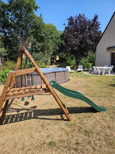 a wooden swing set in a yard at Les LYS in Locronan