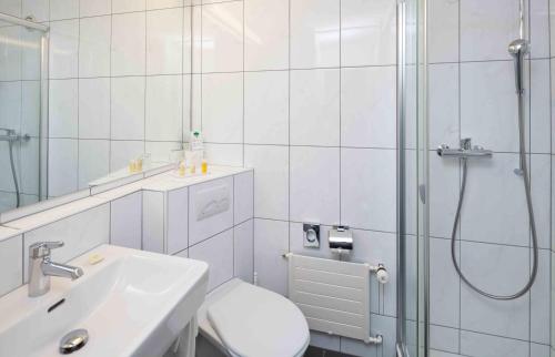 a bathroom with a shower and a toilet and a sink at Rigi Kaltbad Swiss Quality Hotel in Rigi Kaltbad