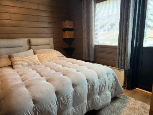 a bedroom with a large white bed with a window at Himos Tomba, Areenan alue in Jämsä