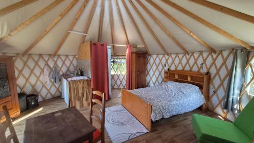 a bedroom in a yurt with a bed and a table at Yourtes insolites in Querrien