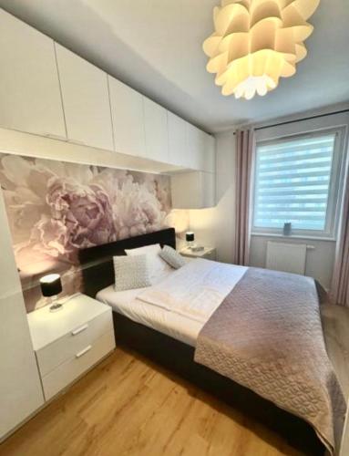 a bedroom with a large bed and a chandelier at Loft No 35 Premium Apartment in Głogów