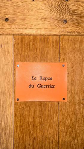 an orange sign on a wooden door with the words ly repros au curator at La Maison du Passage - Chambres - Suites premium, Spa, Piscine et Restaurant in Martignargues