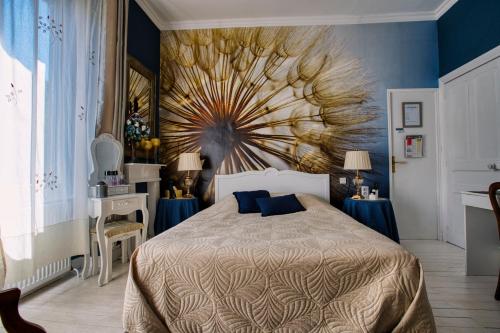 a bedroom with a bed with a peacock painting on the wall at Chambre d'hôtes Bounty - terrasse, cuisine privée, garage in Olliergues