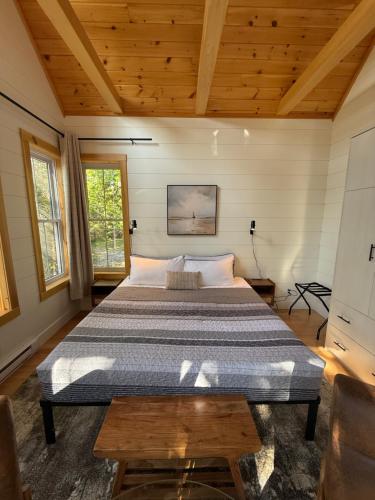 a bedroom with a large bed in a room with wooden ceilings at Dock 124 - Adults Only, Waterfront B&B in Tobermory