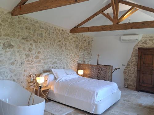 a bedroom with a white bed and a bath tub at Bed and Breakfast with a View & Pool Bastide de Marie Grasse in Grasse