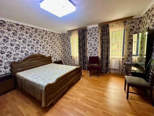 a bedroom with a bed and a chair at BABILINA HOTELs in Simonet'i
