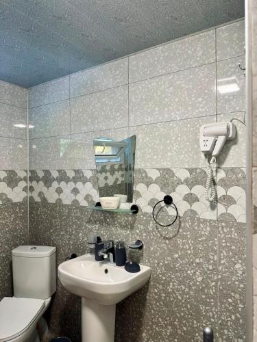 a bathroom with a sink and a toilet and a mirror at BABILINA HOTELs in Simonet'i