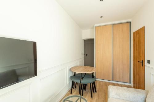 a room with a table and a chair and a tv at L'Aube des Alpes Hyper Centre Élégance et Confort in Thonon-les-Bains