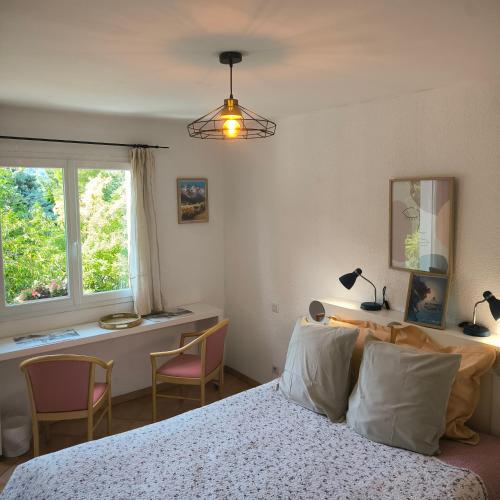 a bedroom with a bed and a desk and a window at Chambre Studette indépendante in Briançon