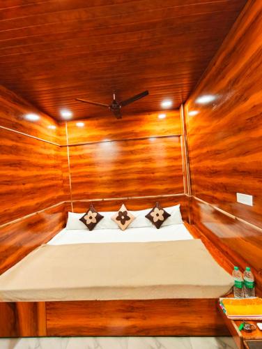 a bedroom with a bed in a wooden room at HOTEL OM PALACE NEAR MAHAKALESHWAR TEMPlE in Ujjain