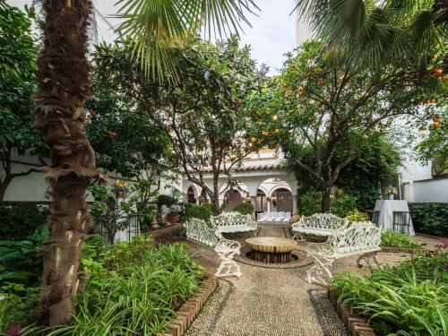 a garden with white chairs and a fountain at Eurostars Conquistador in Córdoba