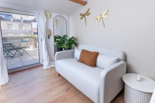 a white couch in a living room with a window at Le Cocon Perché - Centre Ville - Parking - Clim in Valence