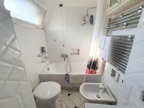 a white bathroom with a toilet and a sink at La Casetta in Genoa