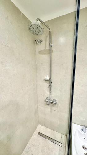 a shower with a glass door next to a sink at Hotel Cap Polonio in Ushuaia