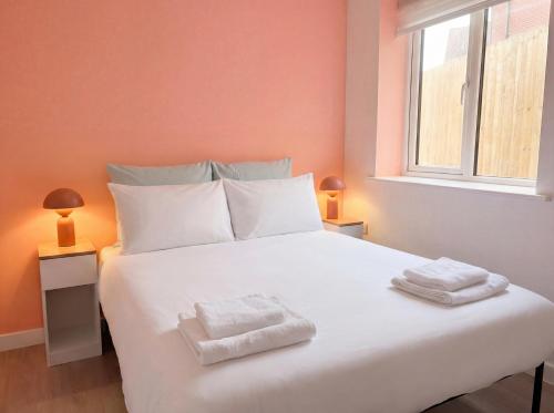 a bedroom with a large white bed with towels on it at Zozy Clitterhouse in London