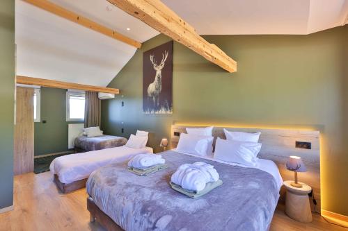 two beds in a room with green walls at Domaine Le H in Munster